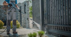 Man power washing electric gate