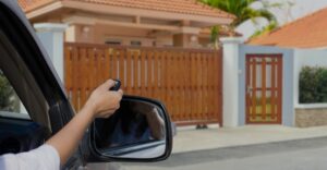Car pulling up to an electric gate using a key fob remote to open it