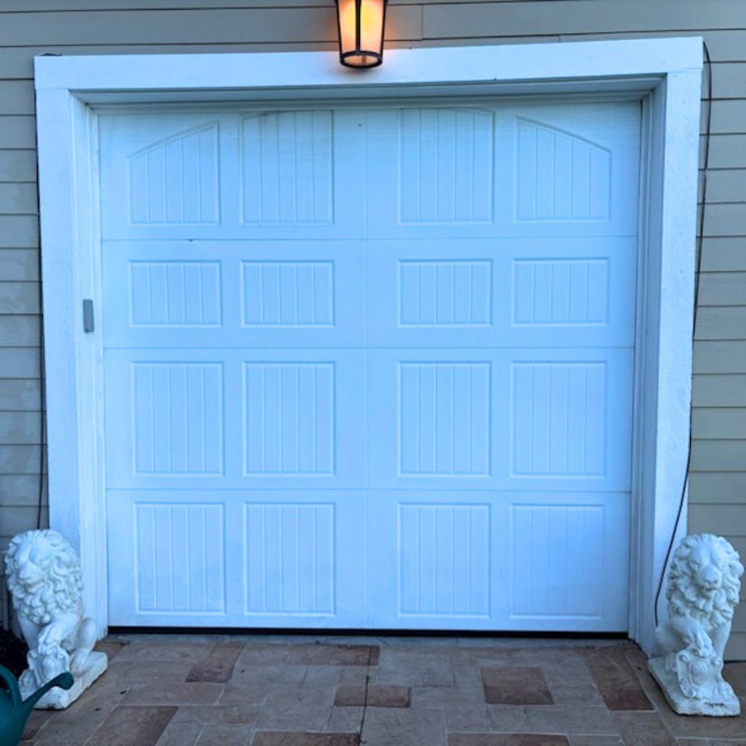 a closed garage door exterior with a light on above
