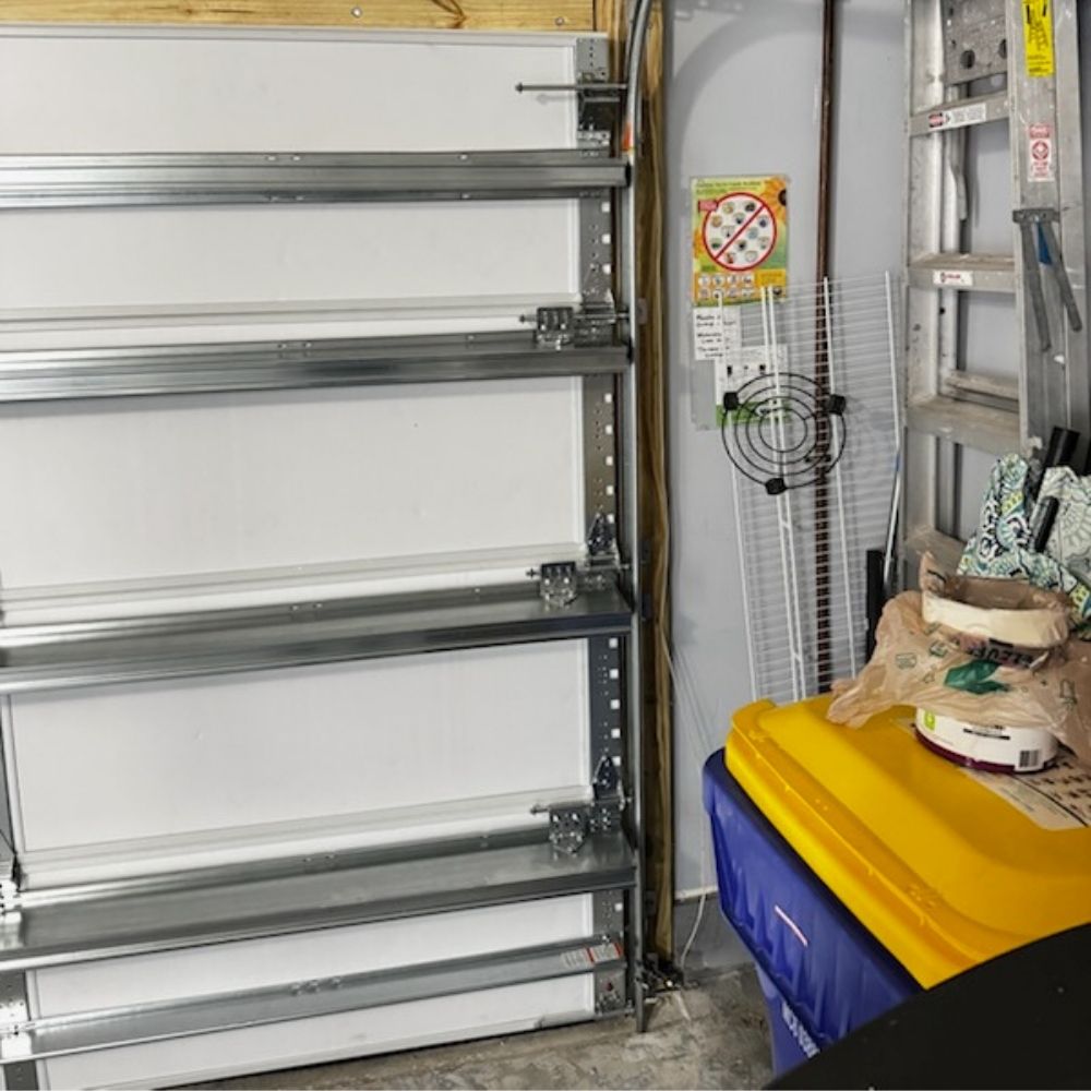 Close-up of a vertical garage door track and roller assembly securely mounted to the wall, demonstrating proper alignment for smooth door operation.