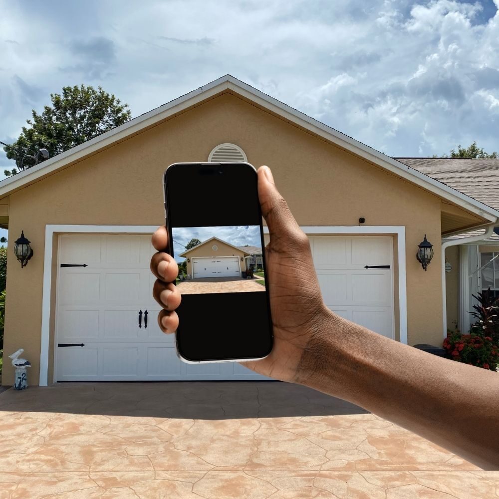 a phone displaying image of garage with garage in background